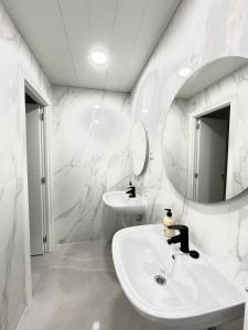 a white bathroom with a sink and a mirror at Hostel Almansa in Madrid