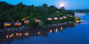 a row of lit up lights on an island in the water at Serena Mivumo River Lodge in Mkalinzu