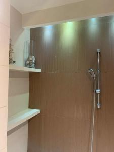 a shower in a bathroom with a wooden wall at Apartament NA WRZOSACH in Kielce +12 photos