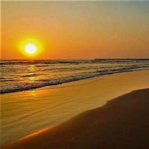 - un coucher de soleil sur une plage donnant sur l'océan dans l'établissement Petropolis, à Juan Lucas