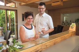 a man and a woman standing at a bar at Weingut Familie Bauer in Großriedenthal