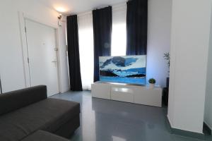Una sala de estar con un sofá y un televisor de pantalla plana. en Oliva Nova MET & BEACH Apartment, en Casas Devesa