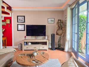 a living room with a tv and a table at Ferienhaus "Kleine Auszeit" in Zingst in Zingst