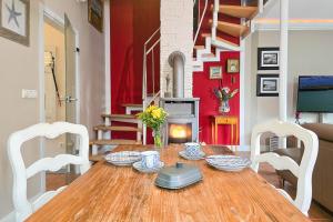 a dining room with a wooden table and white chairs at Ferienhaus "Kleine Auszeit" in Zingst in Zingst +11 photos