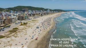 a beach with a lot of people and the ocean at Hospedagem Vô João in Gravatal