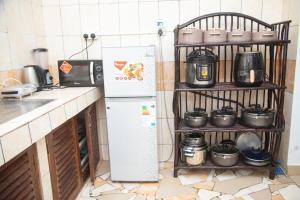 una cucina con frigorifero e mensola con pentole e padelle di Ndoto apartment a Ukunda Altre 3 foto