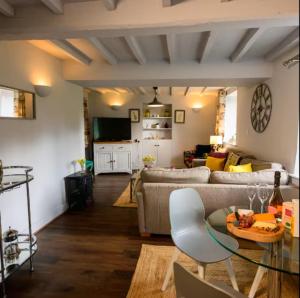 a living room with a couch and a table at Cotswolds Corner Cottage in Moreton in Marsh