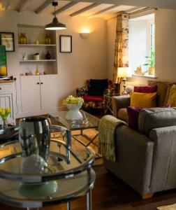a living room with a couch and a table at Cotswolds Corner Cottage in Moreton in Marsh +33 photos