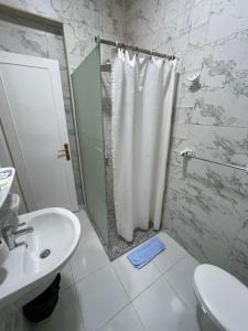 a bathroom with a shower and a toilet and a sink at Rezeiky Hotel & Camp in Luxor