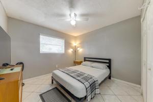 a bedroom with a bed and a ceiling fan at Fenced-In Yard Home 3 Mi to Hard Rock Stadium! in Lake Lucerne