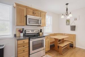 a kitchen with a stove and a microwave at 3BR Cottage Near Downtown Kingsport in Kingsport +29 photos