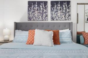 a bedroom with a bed with blue and orange pillows at 3BR Cottage Near Downtown Kingsport in Kingsport