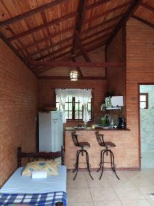 a bedroom with a bed and two chairs in a room at Chalés Vale Verde in Lima Duarte +18 photos