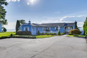 a large blue house with a driveway at Pool and Stunning Water Views Kent Island Home! in Stevensville