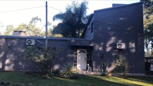 a house with a dog sitting in front of it at Casa SIÓN in Ituzaingó