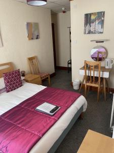 Un dormitorio con una cama con una manta morada. en Evanescent- Adult Only, en Blackpool