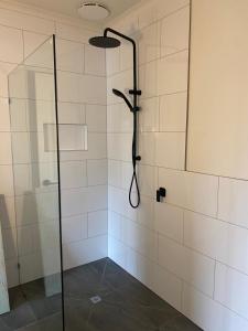 une salle de bain avec une douche avec une porte vitrée dans l'établissement Serenity Cottage Wonthaggi, à North Wonthaggi 33 autres photos