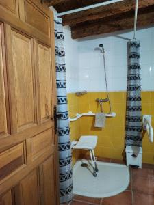 une salle de bain avec une douche et une chaise dedans dans l'établissement Anticca Rural hasta 11 personas, à Atauta
