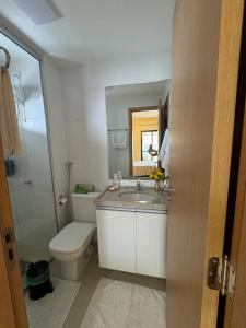 a bathroom with a sink and a toilet and a mirror at Modern Condo Doca in Umarizal in Belém