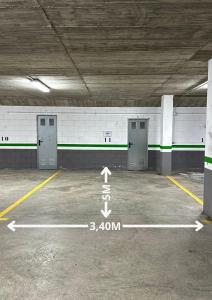 an empty parking lot with three doors in a parking garage at Barthe Holidays I Apartamento moderno 5PAX en Arinsal I Ideal para familias, Parking I Coma Pedrosa in Arinsal