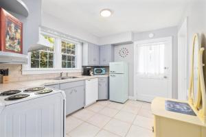 Il comprend une cuisine blanche équipée d'une cuisinière et d'un réfrigérateur. dans l'établissement 3BR, 2BA house steps from historic Jonesborough, à Jonesborough