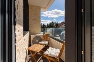 ズラティボールにあるZlatibor Villa, Sauna, Free Parking near Lake and Ski Centerのバルコニー(椅子2脚、ファン付)