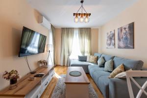 ズラティボールにあるZlatibor Villa, Sauna, Free Parking near Lake and Ski Centerの青いソファとテレビのあるリビングルーム