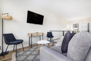 ジョンソンシティにあるNew construction 2nd level apartment * Downtown JCのソファと壁掛けテレビのあるリビングルーム