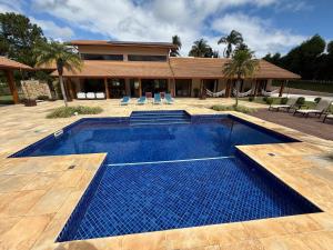 a swimming pool in front of a house at Vibella Ibiúna in Ibiúna