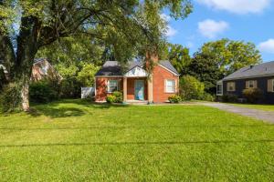 une maison en briques avec un arbre dans la cour dans l'établissement 3BR, 2BA house steps from historic Jonesborough, à Jonesborough
