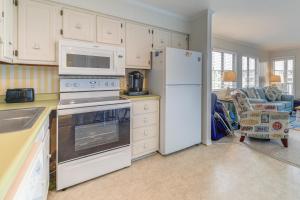a kitchen with white appliances and a living room at Steps to Sand! Condo with 2 Pools in Atlantic Beach in Atlantic Beach