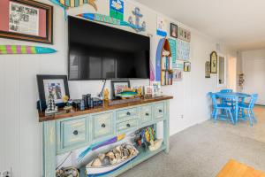a room with a blue dresser with a flat screen tv at Steps to Sand! Condo with 2 Pools in Atlantic Beach in Atlantic Beach