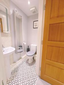 a bathroom with a toilet and a sink at Central City Apartment - Free Parking in Belfast