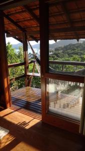 an open door to a balcony with a view of trees at Pousada Porto Belo in Porto Belo