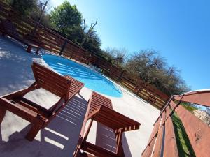 a swimming pool with two wooden chairs next to it at Entrecalandrias in Colón