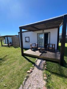 ein Haus mit einer Holzterrasse mit einer Bank in der Unterkunft Da Fortune 2 in Barra de Portezuelo + 20 Fotos