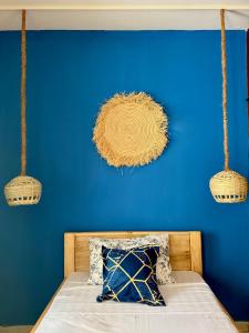ein blaues Schlafzimmer mit einem Bett mit blauer Wand in der Unterkunft Golden Nap hostel in Zanzibar City