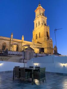 a building with a tower with a table and chairs at Torre de Santa María in Utrera