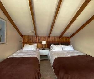 two beds sitting in a room with at Hostal Dinamarca in Temuco