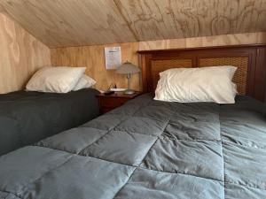 a bedroom with two beds and a table with a lamp at Hostal Dinamarca in Temuco +18 photos