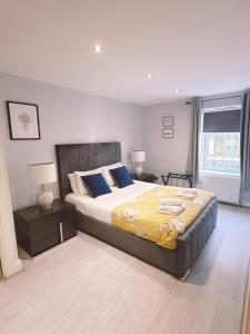 a bedroom with a large bed with blue pillows at Central City Apartment - Free Parking in Belfast
