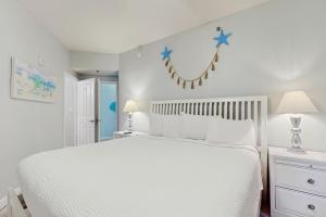 a bedroom with a white bed with stars on the wall at Shores of Panama 2310 in Panama City Beach +23 photos
