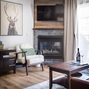 a living room with a fireplace with a tv above it at Westwinds - Funky Basecamp in the Rockies in Canmore