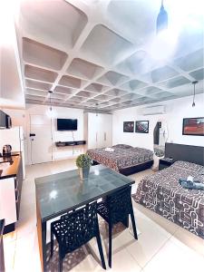 a room with two beds and a table and a couch at Loft Blumenau in Blumenau