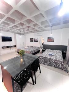 a large room with two beds and a table at Loft Blumenau in Blumenau