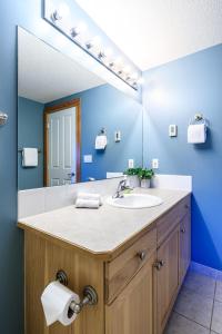 a bathroom with a sink and a mirror at Bluebird - Spacious Luxury Shared Rooftop Hot Tub in Canmore