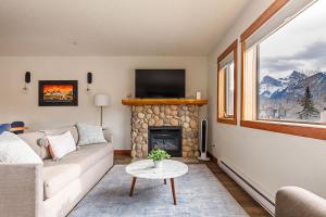 a living room with a couch and a fireplace at Bluebird - Spacious Luxury Shared Rooftop Hot Tub in Canmore