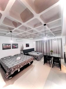 a bedroom with two beds and a table in it at Loft Blumenau in Blumenau