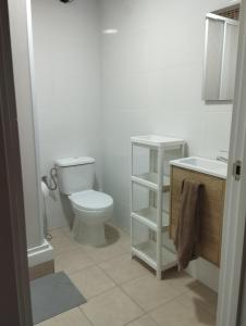 a white bathroom with a toilet and a sink at Apartamentos calatorao in Calatorao +4 photos