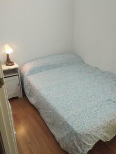 a bedroom with a bed and a night stand with a lamp at Apartamentos calatorao in Calatorao